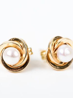Gold earrings with pearls on white