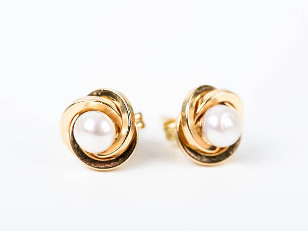 Gold earrings with pearls on white