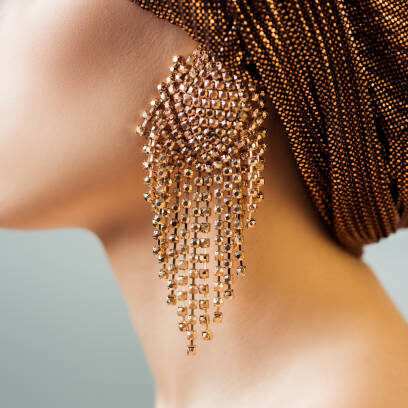 Cropped view of young woman in turban and golden earring isolated on grey