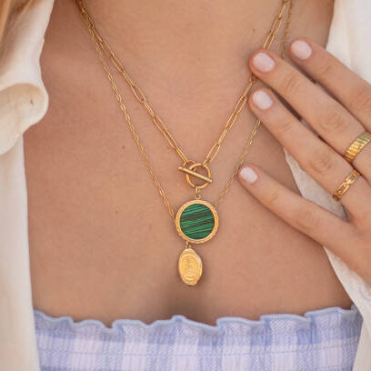 Young woman wearing golden jewelry. golden necklace and golden rings.